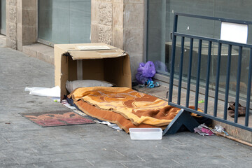 Beggar's place to sleep on the street with a wool blanket and a cardboard box