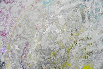 Sanded studio floor showing an abstract mix of pastel colors like violet, blue, yellow, and white. Layers of paint form an expressive texture from years of artistic bodypainting work