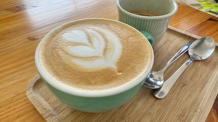 Artistic Latte Coffee Served on Wooden Tray in Cozy Cafe Setting