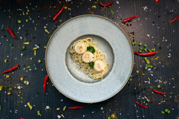 close up of a plate of pasta with scallops inside
