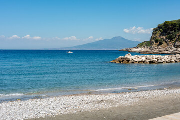 Beach of the village Marina di Puolo in Massa Lubrense with Vesuvius in the distance, the blue waters in the Sorrento peninsula Naples. Italy