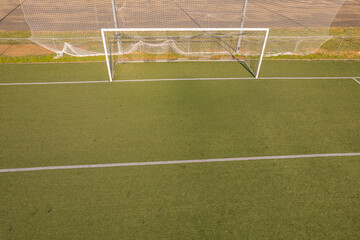 overhead perspective of a modern soccer field with a goal and white lines, aerial drone view