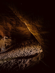 Entrance to a sand cave in the middle zone with steep and rocky walls.
