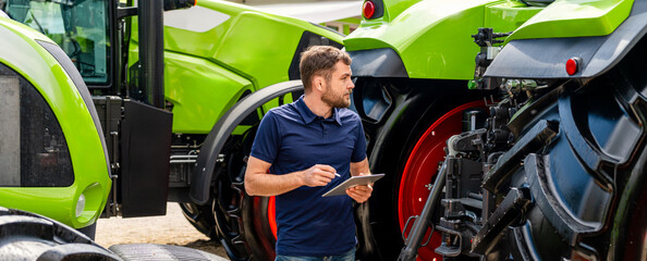 Male technician inspecting agricultural machinery with digital device outdoors