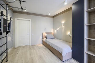 modern bedroom with a bed, desk, wardrobe, and exercise equipment. The color palette is neutral with pops of blue