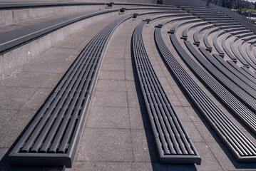 Long benches on concrete ledges in a modern amphitheater.