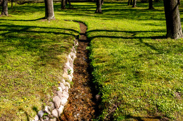 Drainage ditch for water in the park in summer.