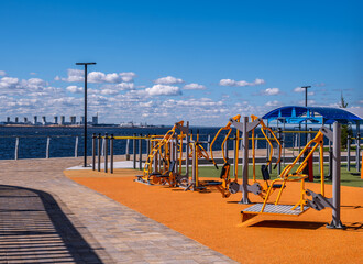 Fototapeta premium A sports ground with exercise equipment on the shore of the sea bay.