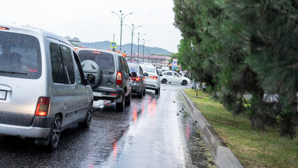 Heavy traffic jams on a rainy day in the city with blurred vehicles and reflections on wet pavement