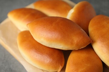 Tasty baked patties on light grey table, closeup