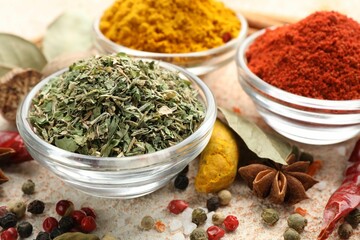 Different aromatic spices on color textured table, closeup