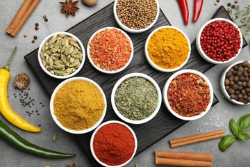 Different aromatic spices on grey table, flat lay