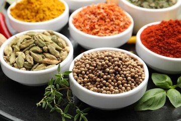 Different aromatic spices in bowls on table, closeup