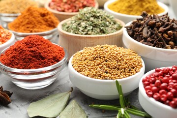 Different aromatic spices on grey table, closeup
