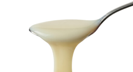 Creamy dessert sauce cascading off spoon