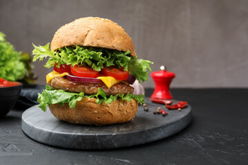 Delicious hamburger with patty served on black table, closeup. Space for text