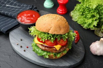 Delicious hamburger with patty served on black table, closeup