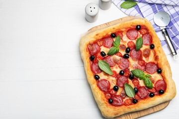 Tasty homemade pizza and cutter on white wooden table, flat lay. Space for text