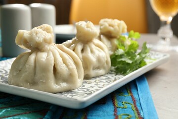 Delicious khinkali served with cilantro on grey table, closeup