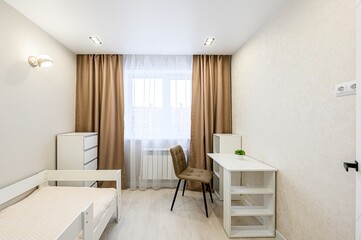 Bright bedroom with a bed, desk, and window with curtains. White furniture and light walls create a clean, simple aesthetic