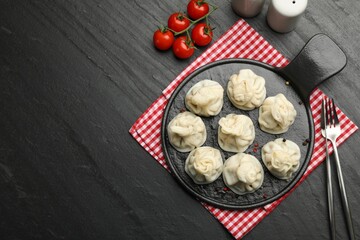Delicious khinkali served on black table, flat lay. Space for text