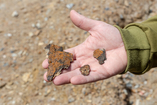 Male hand holding ironstone material close-up