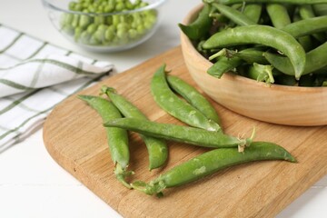 Fresh ripe green peas on white wooden table, closeup