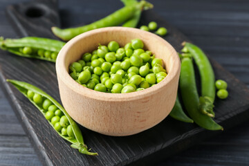 Fresh ripe green peas on black wooden table, closeup