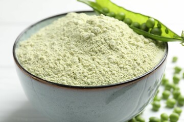Protein powder in bowl and green peas on table, closeup
