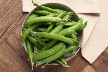 Fresh ripe green peas on wooden table, top view