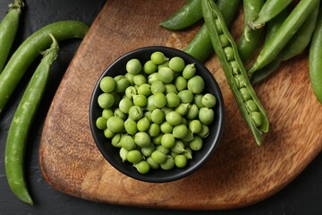 Fresh ripe green peas on black table, flat lay