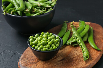 Fresh ripe green peas on black table, closeup
