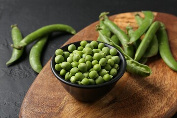 Fresh ripe green peas on black table, closeup