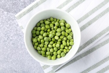 Fresh ripe green peas on grey table, top view
