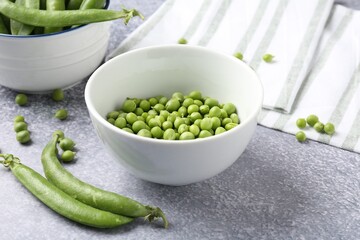 Fresh ripe green peas on grey table, closeup