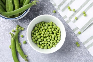 Fresh ripe green peas on grey table, flat lay