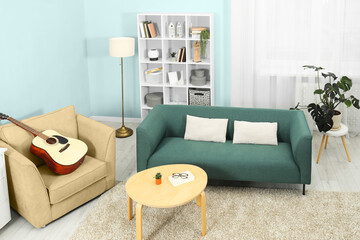 Stylish living room with comfortable sofa and light blue wall. Interior design