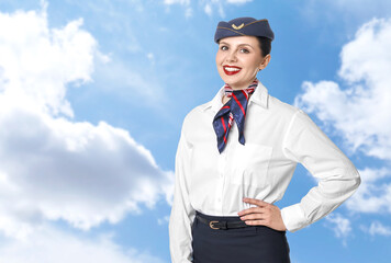 Smiling stewardess against blue sky with clouds