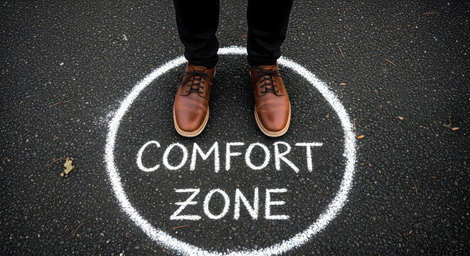 Man standing inside comfort zone circle on asphalt ground. Concept of pushing boundaries and taking risk. Business challenge strategy.