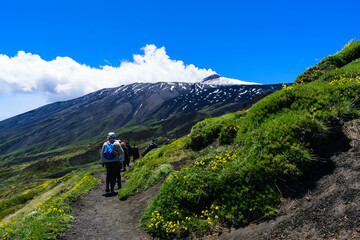 Fototapeta premium Hikers on Mount Etna Against a Dramatic Landscape