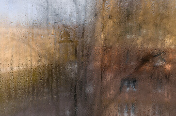  Condensation forms water drops on indoor window glass, showing high humidity.