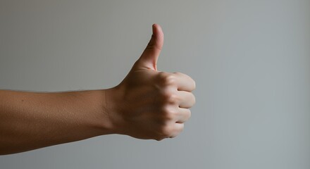 Hand Gesture Showing Thumbs Up Approval Against Neutral Background