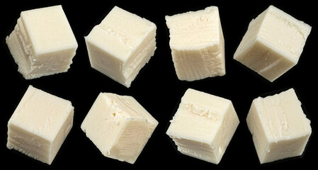 Falling cubes of white cheese isolated on black background