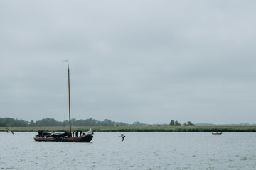 Auslaufendes Plattbodenschiff mit noch nicht gesetzten Segeln auf dem Weg zum IJsselmeer, Lemmer, Niederlande