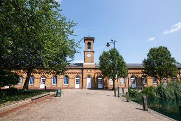 Fototapeta premium A view of the clock tower standing tall beside the RSA Island Centre in Enfield Island Village, showcasing a blend of history and modern community space.