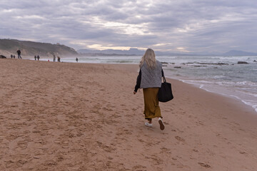 Woman walking in casual clothes on the beach. French Basque Country