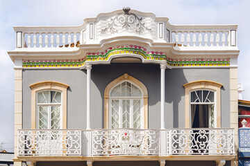 Ornate grey building with white balcony and colorful trim