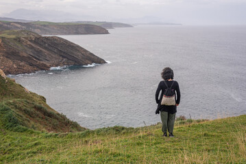 Woman contemplating the cliffs of the Cantabrian Coast
