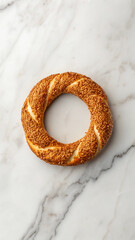 A delicious freshly baked turkish simit bread ring with sesame seeds on marble
