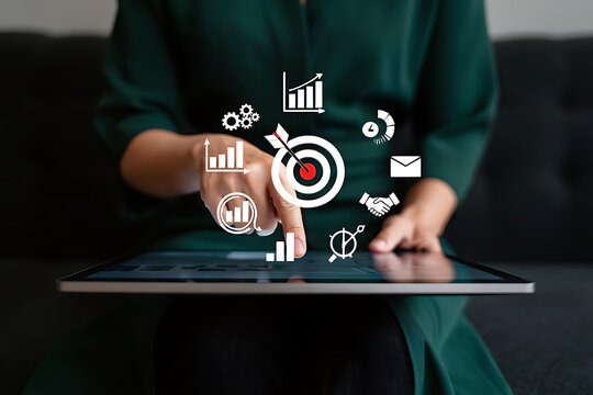 Businesswoman targeting goals using digital tablet technology with business icons